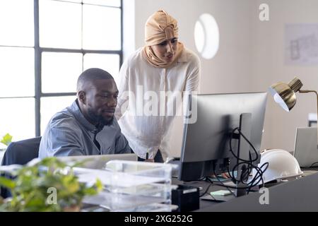 Collaborating on project, colleagues using desktop computer in modern office Stock Photo