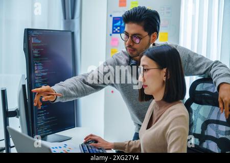 asian and Indian Developer team discussion feedback analysis coding data with software computer at office Stock Photo