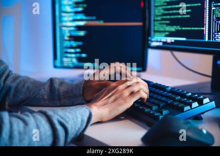 close up hand of Asian prompt engineer develop coding app with software data sitting in front of computer monitor at office Stock Photo