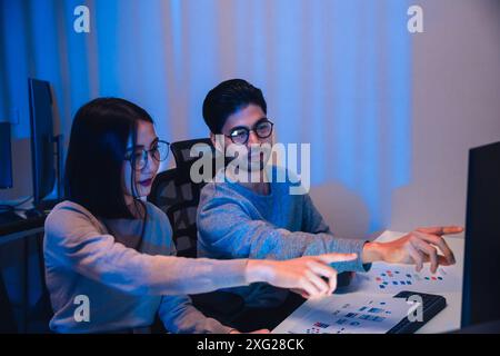 asian and Indian Developer team discussion feedback analysis coding data with software computer at office Stock Photo