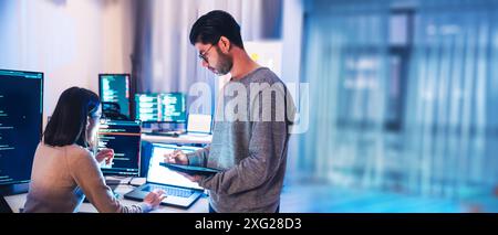 asian and Indian Developer team discussion feedback analysis coding data with software computer at office Stock Photo