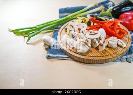 Sliced vegetables such as mushrooms, bell peppers, eggplant and spring onions on a wooden cutting board for a healthy vegetarian meal, copy space, sel Stock Photo