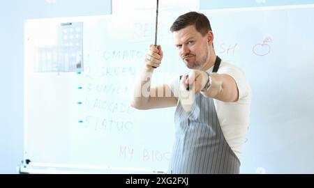 Standing man hold sharp kitchenware for cooking, knife sharpening on kitchen Stock Photo
