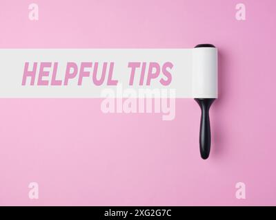 Helpful tips. Useful tips, advice, and tricks for business and life. Lint roller with white trace on pink background with the message helpful tips. Stock Photo