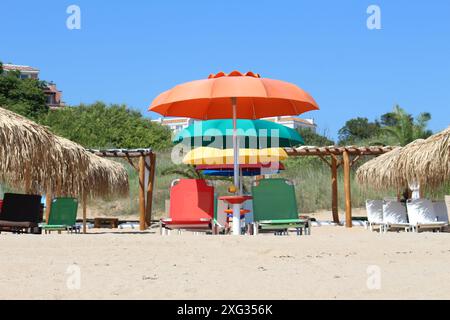 Colorful umbrellas on sandy beach with colorful chaislong Stock Photo