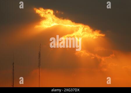Gorgeous Crepuscular Rays or God Rays Breaking Through Golden Sunset sky Stock Photo