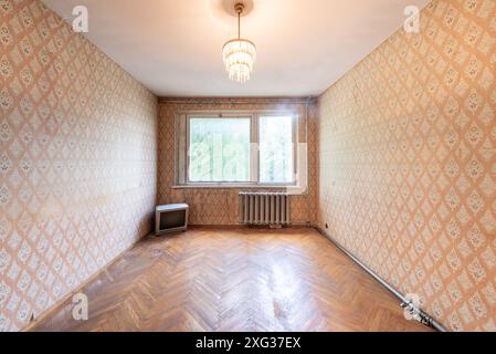Living room in bad condition in an abandoned building. Abandoned house interior. Dirty Room. Old Soviet Russian Poor Interior. Shabby wooden floor. TV Stock Photo