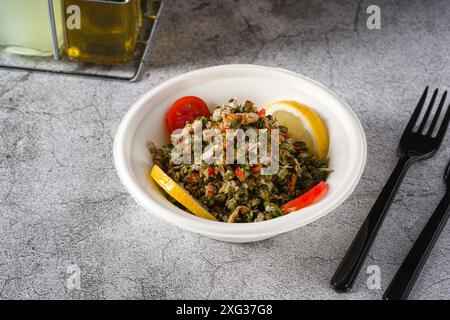 Healthy salad with capers, quinoa and walnuts on stone table Stock Photo