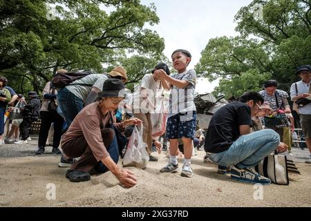 JULY 6, 2024 - People collect sand from a ceremonial dohy following a dohyo-iri purification ceremony at Atsuta Shrine in Nagoya, Japan. Each year, prior to the start of the Nagoya Grand Sumo Tournament, sumo grand champions, or yokozuna, perform a dohyo-iri ceremony to pray for a safe tournament, or basho. The Nagoya Basho is one of six major tournaments held throughout the country each year. Credit: Ben Weller/AFLO/Alamy Live News Stock Photo