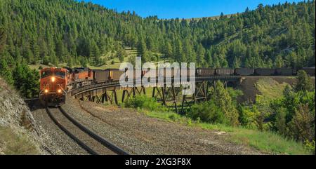 panorama of a coal train heading to mullan pass on the continental divide over a trestle near austin, montana Stock Photo