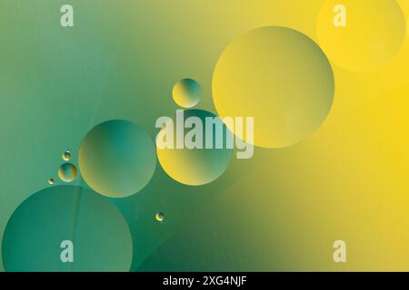 Close up of oil drops on water surface with yellow and green background Stock Photo