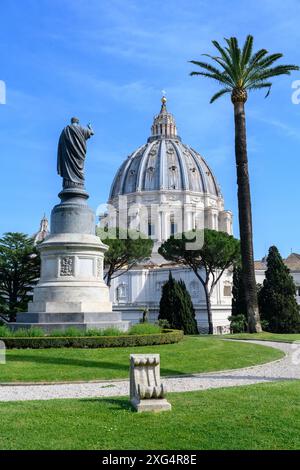 A statue of St Peter in the Vatican Gardens. The dome of St Peter’s Basilica seen in the background. Stock Photo