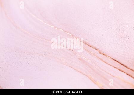 A close-up shot of a light pink surface with delicate gold veins. The texture is smooth and slightly glittery Stock Photo