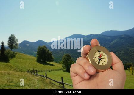 Man using compass in mountains, closeup. Navigational instrument Stock Photo