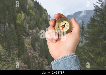 Man using compass in mountains, closeup. Navigational instrument Stock Photo