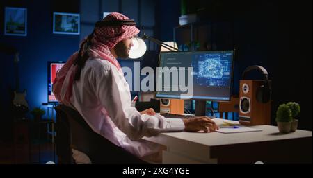 Experienced developer updating neural networks, writing intricate binary code scripts on computer. Muslim worker uses digital device programming to upgrade AI simulation model Stock Photo