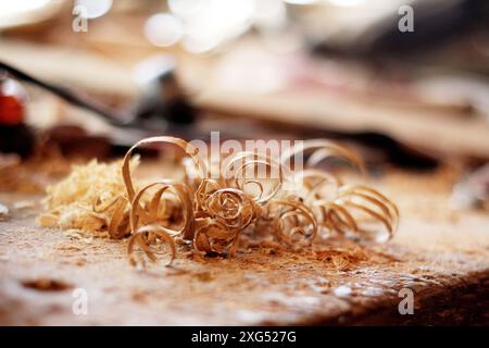 the carpenter's hands are cut with a tool on a board, a carpenter works in a workshop, a chisel in wood, sawdust Stock Photo