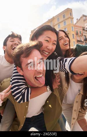 Group of young happy friends people posing having fun for picture sunny day tourism outdoors. Stock Photo