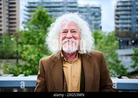Portrait mature joyful long gray hair and beard male grandfather posing looking smiling at camera. Stock Photo