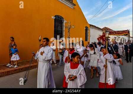 The streets of Mompox, Colombia, come alive during the Corpus Christi celebration with vibrant processions, flower carpets, and devout locals honoring this sacred Catholic tradition. Stock Photo