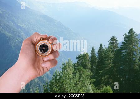 Man using compass in mountains, closeup. Navigational instrument Stock Photo