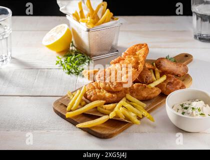 Fish chips chopping board with lemon sauce Stock Photo