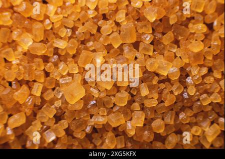 Extreme macro. Sugar crystals. Close-up of brown cane sugar on a plane. Texture or background of wholesome brown sugar Stock Photo
