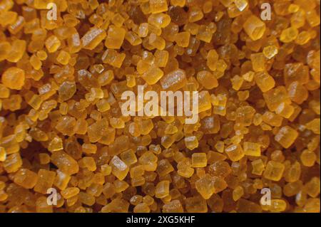Extreme macro. Sugar crystals. Close-up of brown cane sugar on a plane. Texture or background of wholesome brown sugar Stock Photo