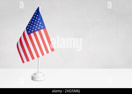 USA american table flag on gray textured wall with Copy space for text, designs or drawings Stock Photo