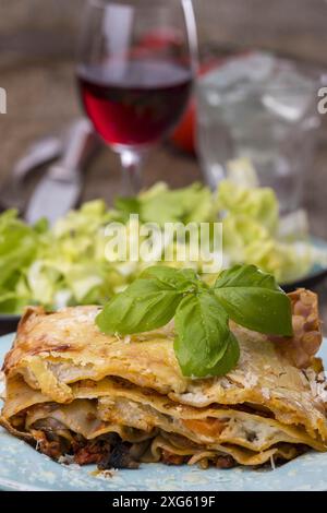 Lasagne with salad on dark wood Stock Photo