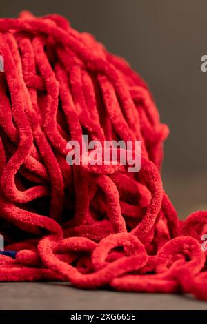 red velour threads for knitting things, new soft red threads with traces of other threads in close-up Stock Photo