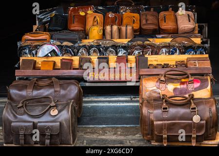 Shelf with fashion bags in a store. Close up of different leather bags on market. Modern colorful bags for sale. Leather accessories purses, handbags Stock Photo