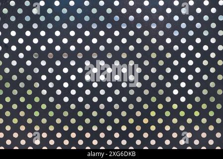Pattern of small circular holes on a perforated metal surface Stock Photo