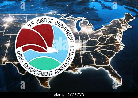 KYIV, UKRAINE - JUNE 26, 2024 U.S. Justice Department Drug Enforcement Administration coat of arms on paper map of United States of America Stock Photo