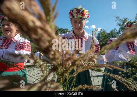 Moscow, Russia. 6th of July, 2024. Women weave wreaths of wildflowers during a celebration of the Belarusian holiday 'Kupalle' in Ostankino Park in Moscow, Russia. Kupalle or Ivana Kupala Day, also known as Ivana-Kupala or Kupala Night, is a traditional pagan holiday folk celebration in eastern Slavic cultures. Girls create and wear flower wreaths and perform various rituals. Initially, Ivana-Kupala was a pagan fertility rite that was also connected to the celebration of the summer solstice when nights are the shortest Stock Photo