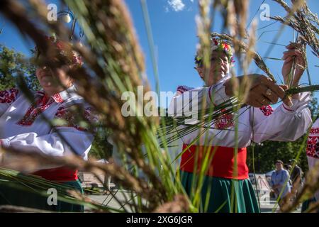 Moscow, Russia. 6th of July, 2024. Women weave wreaths of wildflowers during a celebration of the Belarusian holiday 'Kupalle' in Ostankino Park in Moscow, Russia. Kupalle or Ivana Kupala Day, also known as Ivana-Kupala or Kupala Night, is a traditional pagan holiday folk celebration in eastern Slavic cultures. Girls create and wear flower wreaths and perform various rituals. Initially, Ivana-Kupala was a pagan fertility rite that was also connected to the celebration of the summer solstice when nights are the shortest Stock Photo