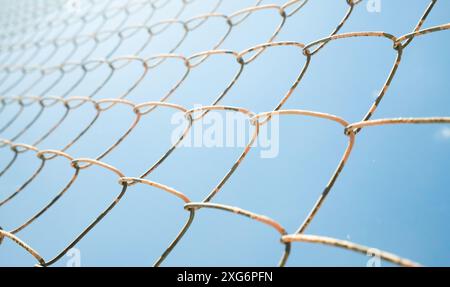 metal fence wire net on blue sky background Stock Photo