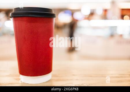 Red paper coffee cup mockup with space for text, blurred background Stock Photo