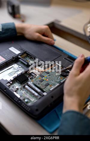 close-up technician or Engineer installing CPU microprocessor to motherboard socket on workplace in the office. Concept of repairing, upgrade, service Stock Photo