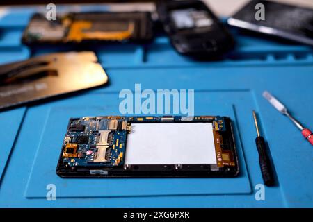 smartphone, phone's components lying on table after disassembling. broken mobile phone withtools, close-up photo Stock Photo