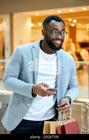 joyful good-looking smart man in fashion clothes doing online shopping, close up side view photo Stock Photo