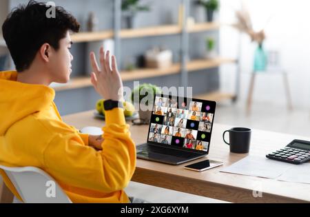 Young Man Participating in Online Meeting With Laptop at Home Stock Photo