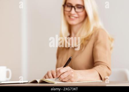 Mature Freelancer Writing Down Plans Project Into Notebook Stock Photo