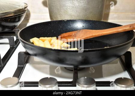 Home furnishings. Kitchen. A frying pan with fried potatoes is on the gas stove. Stock Photo