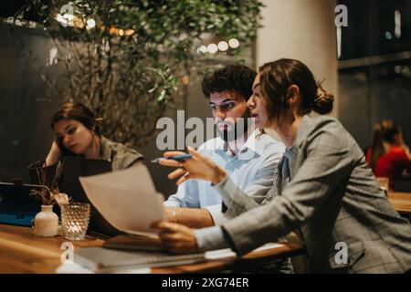 Startup team collaborating on a new project at a casual coffee bar late at night Stock Photo