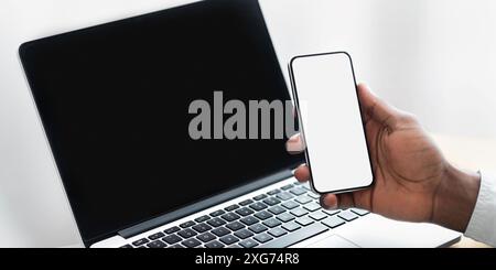 Person Holding Smartphone Near Laptop Stock Photo
