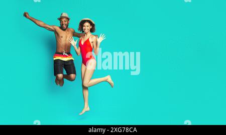 Playful energetic african american couple jumping on blue Stock Photo