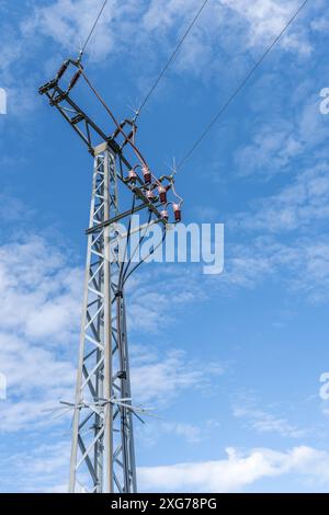 Detailed shot of a power pole with blue sky and white clouds Stock Photo