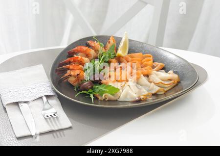 Fish platter salmon and oily fish. On a large plate. Garnished with a slice of lemon and herbs. Healthy food concept. On a light background in a resta Stock Photo