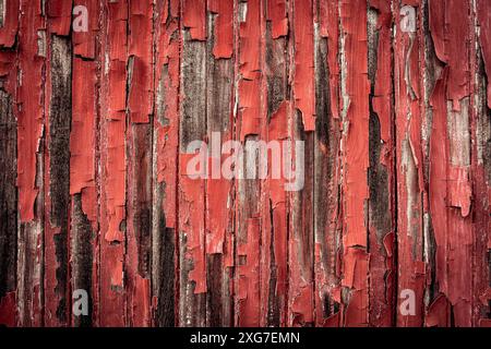 Old red paint peeling off the wooden panels Stock Photo